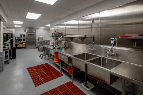 Commercial kitchen sink area where grease traps prevent FOG buildup.