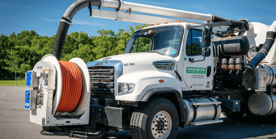 A vacuum truck with Wind River Environmental logo on the side