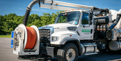 A white vacuum truck with the Wind River Environmental logo on the drive-side door