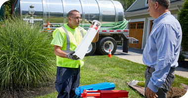 Wind River Environmental technician showing a clean effluent filter to a customer